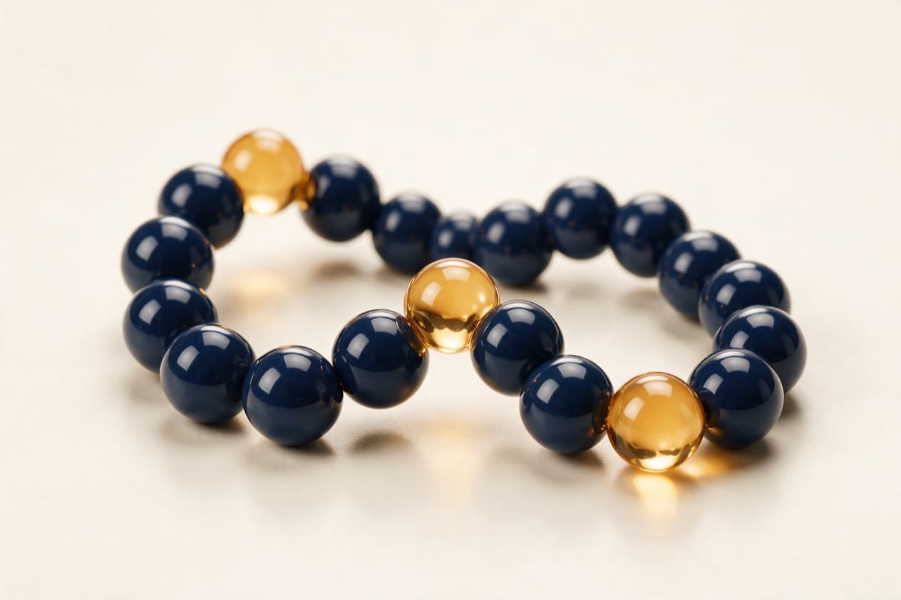 Macro photograph of a peptide chain sculpture: glossy navy spheres with three gold glass spheres